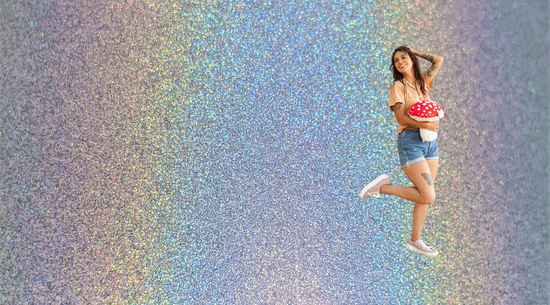 young woman holding a stuffed plush amanita mushroom toy on a sparkly rainbow background as blog header